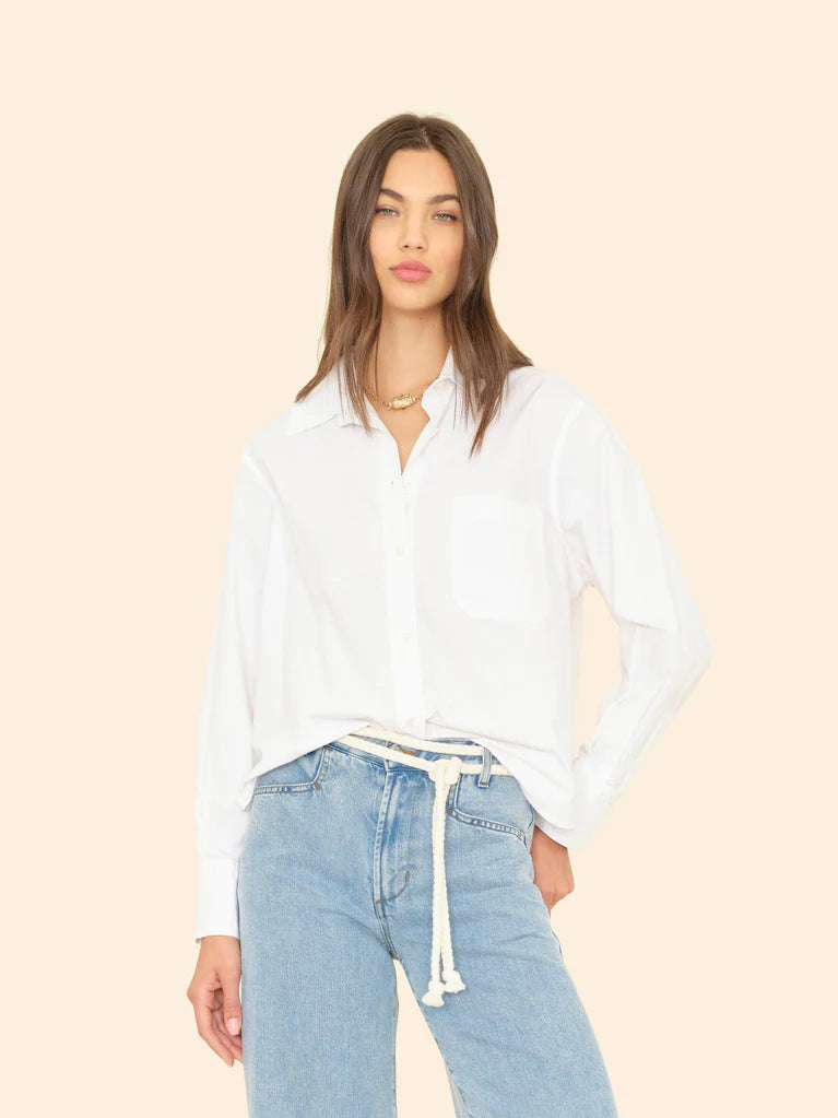 Woman wearing White Monroe Shirt and light blue jeans against a beige background