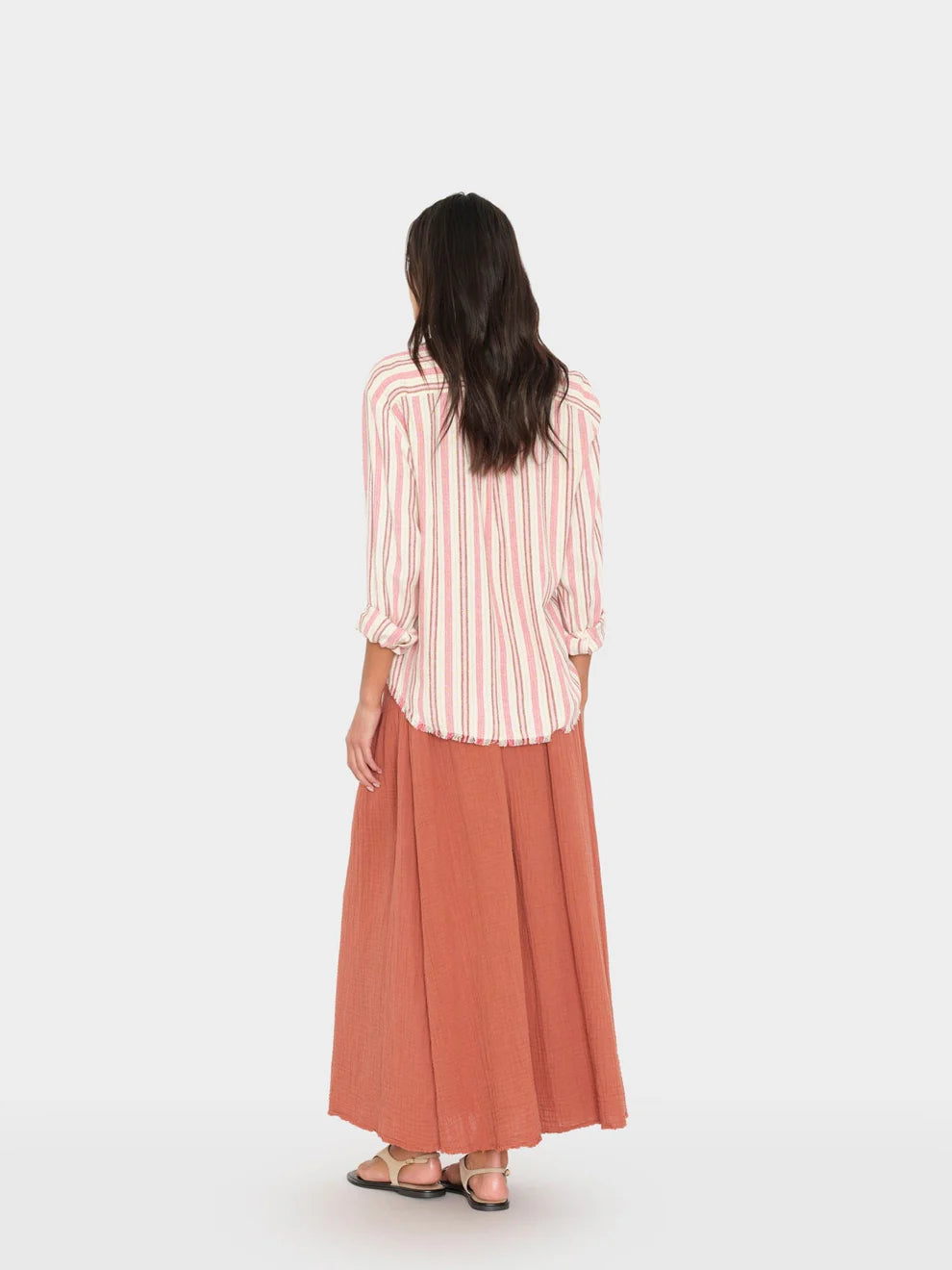 Woman wearing a striped shirt and long skirt on a white background