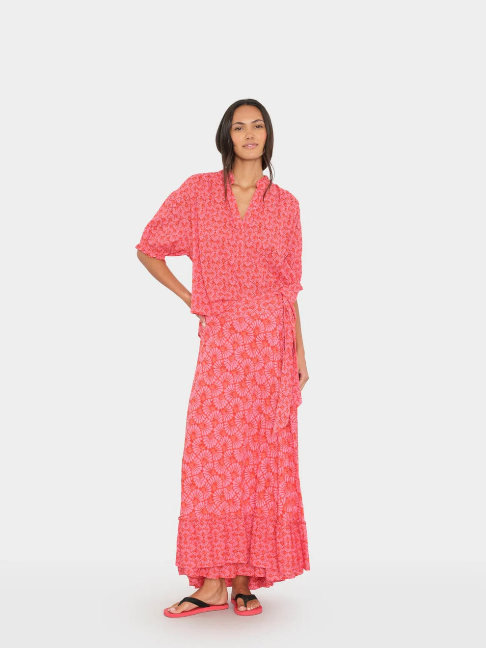 Woman wearing a pink floral dress on a white background