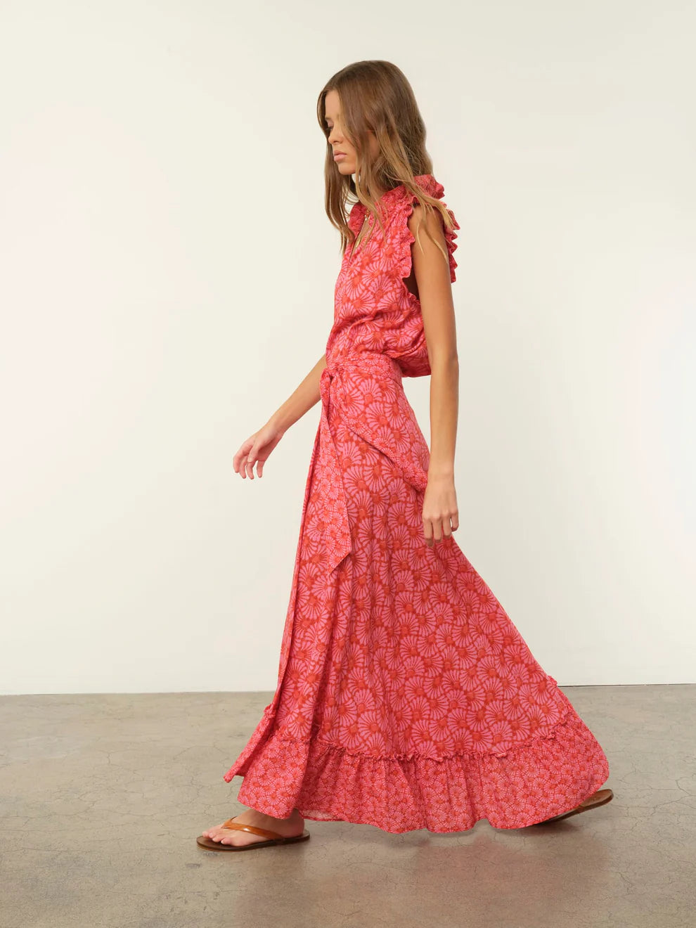 Woman wearing a red patterned dress against a white background