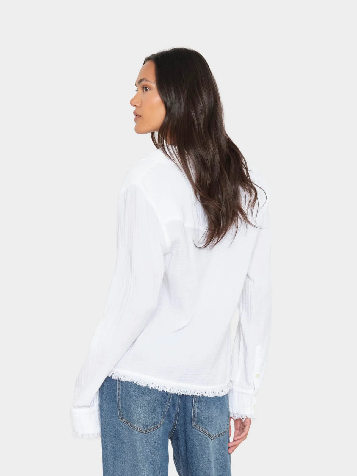Woman wearing a white blouse and blue jeans on a white background
