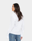 Woman wearing a white blouse and blue jeans on a white background