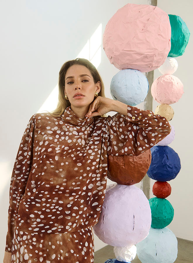 model wearing dapple doe printed top and skirt with art paper mache balls in the background