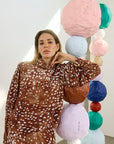 model wearing dapple doe printed top and skirt with art paper mache balls in the background