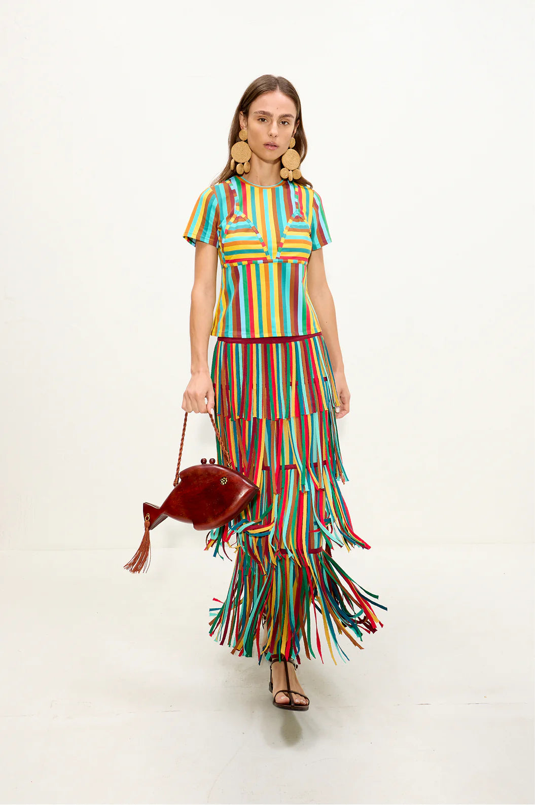 Woman wearing a colorful striped skirt with a white background