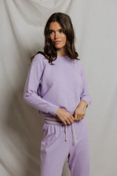 model wearing a purple lounge set on a white background