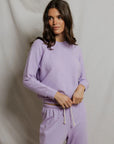 model wearing a purple lounge set on a white background