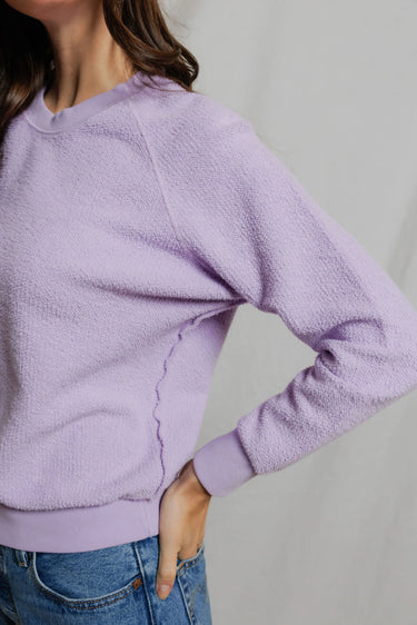 detail photo of a model wearing a purple sweatshirt