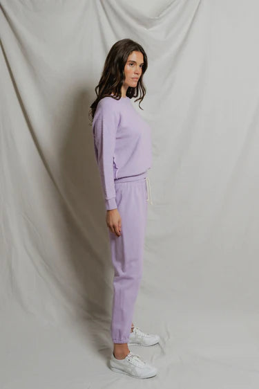 model wearing a purple lounge set on a white background, side view