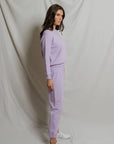 model wearing a purple lounge set on a white background, side view